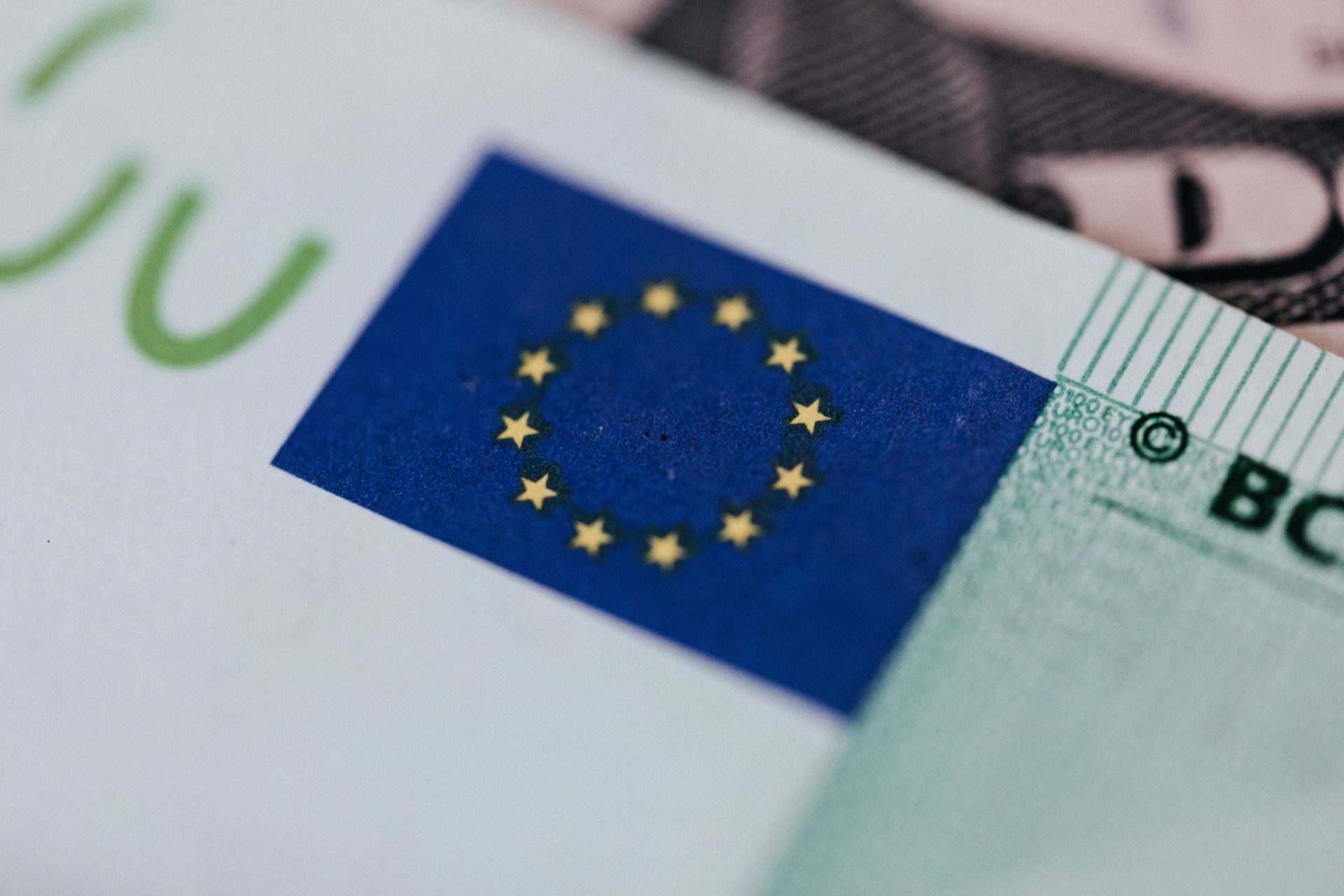 From above of crop banknote of European Union placed on table with dollars